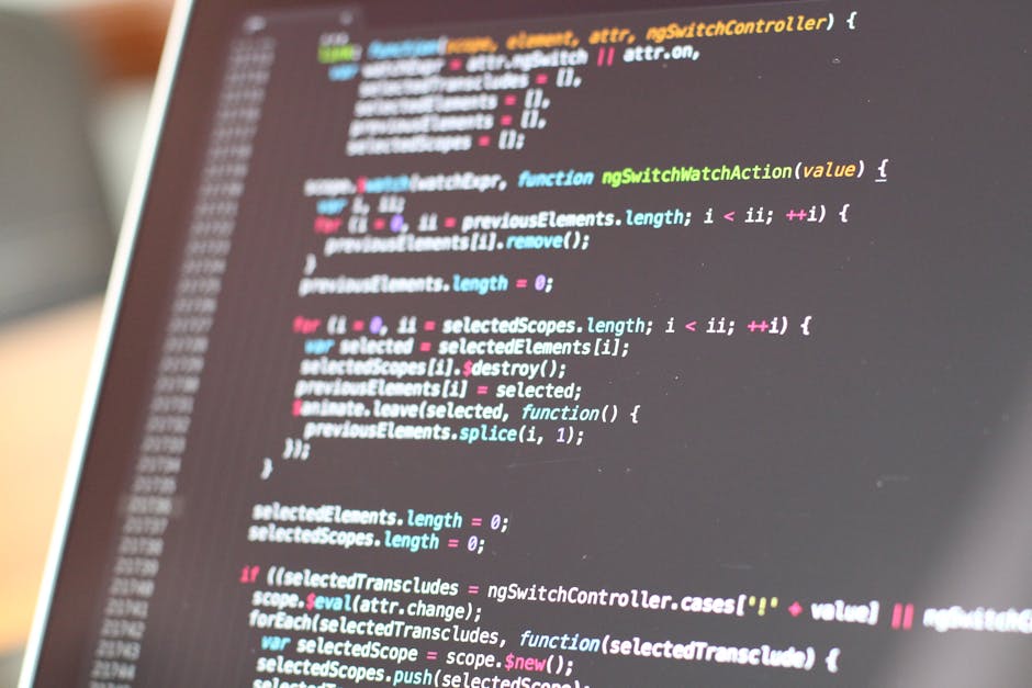 A computer screen displaying a close-up of code in multiple colors, including red, green, blue, and purple, with visible snippets of HTML, CSS, or JavaScript. The code appears slightly blurred and out